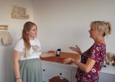 Overleg met een zwangere vrouw over de muurschildering.
